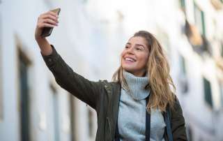 Junge blonde Frau macht Selfie mit Handy